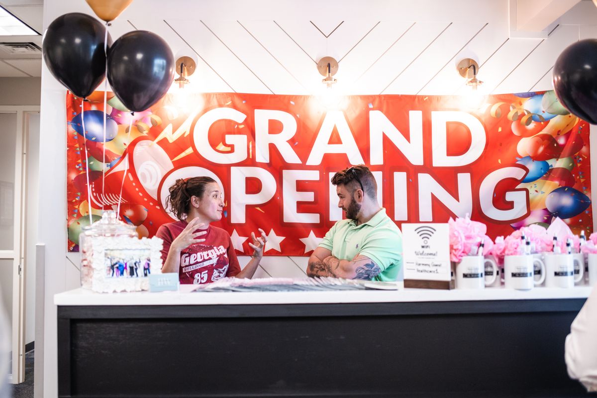 Grand Opening banner and reception desk with balloons