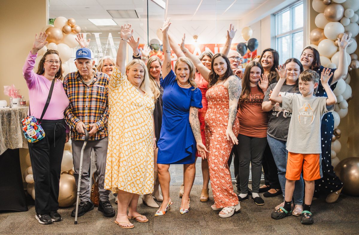 The whole group waving at Harmony Wellness Grand Opening