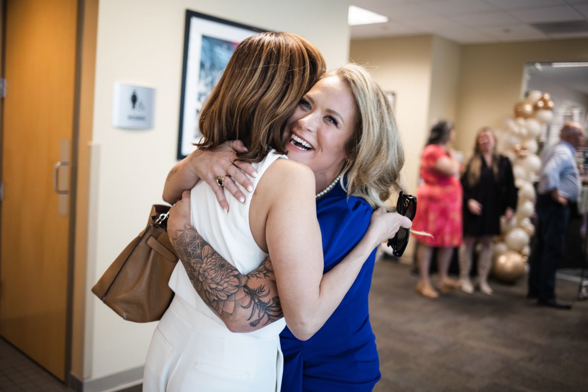 Warm embrace between guests at Grand Opening celebration