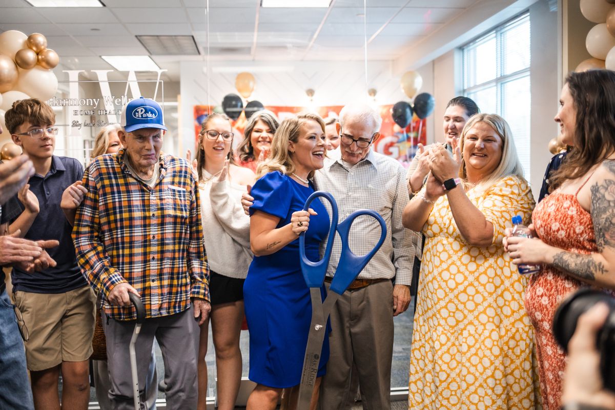 Celebrating after the ribbon cutting with giant scissors